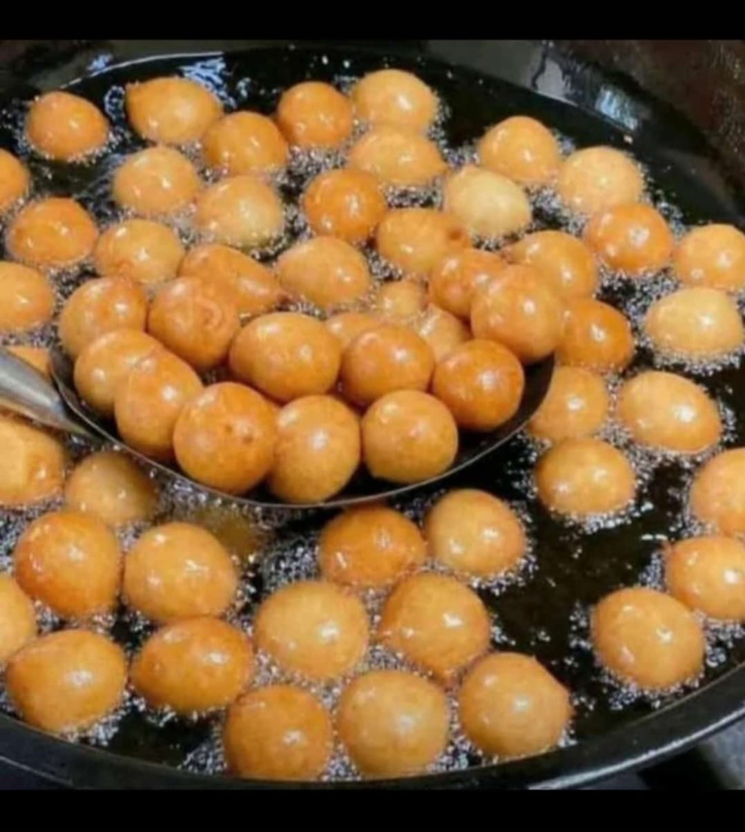 Puff puff frying golden in a pan of oil