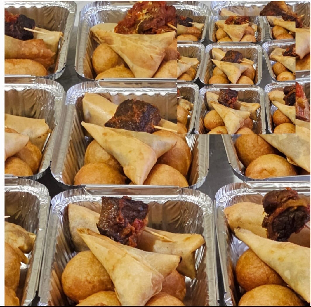 Individual foil platters of Nigerian small chops